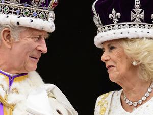 König Charles III. und Königin Camilla sehen sich an, als sie nach ihrer Krönung auf dem Balkon des Buckingham-Palastes stehen (Archivbild).